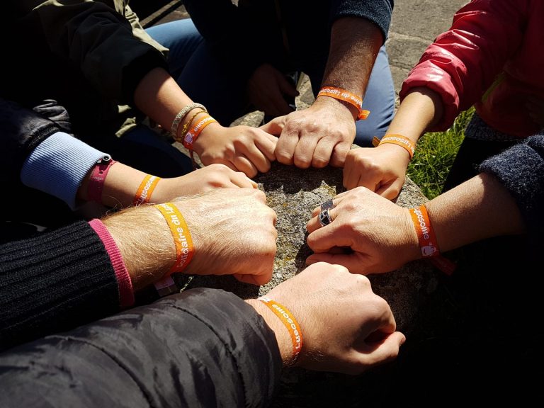 groupe de main avec bracelet du Lysosome en signe de cohesion